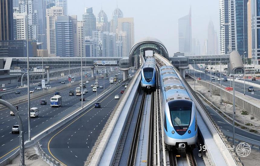 متروی دبی؛ دو قطار آبی‌رنگ در ریلی که در ارتفاع بالا از شهر می‌گذرد.